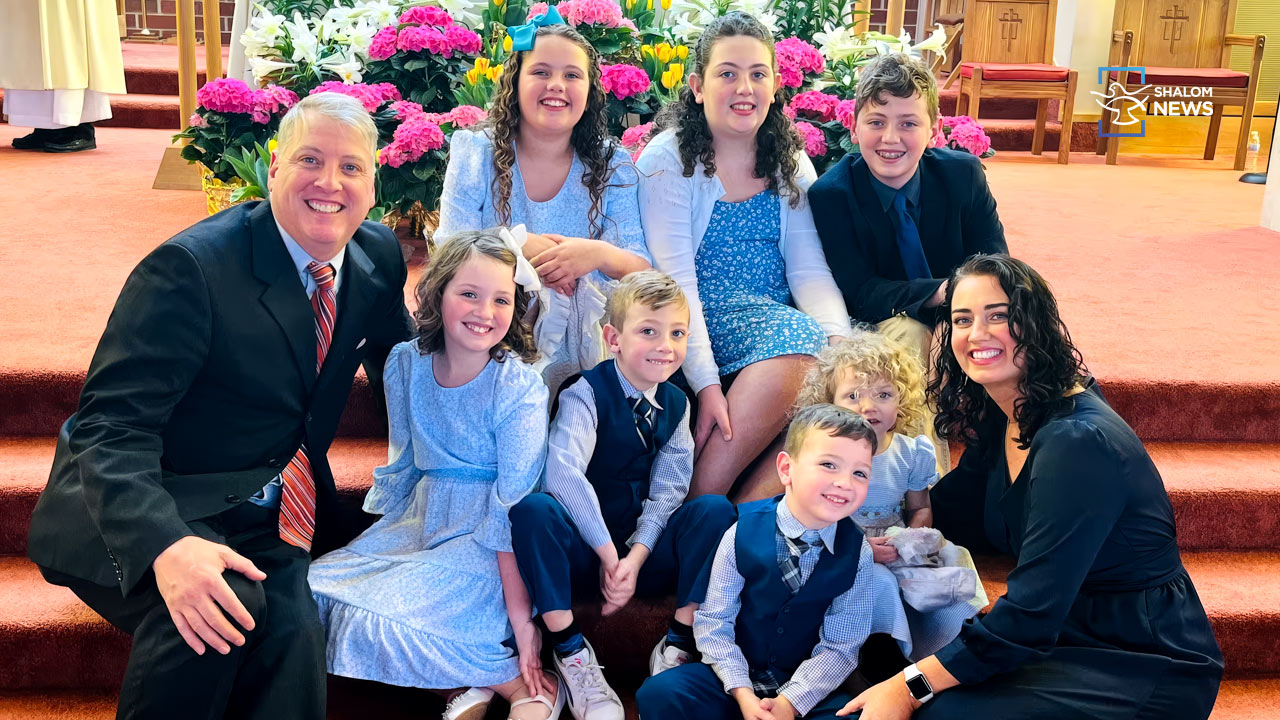 Catholic father gunpoint raid settlement US government